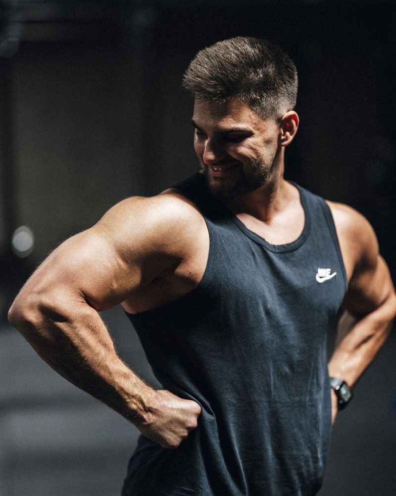 Nderim som smiler mens han står med hænderne på hofterne